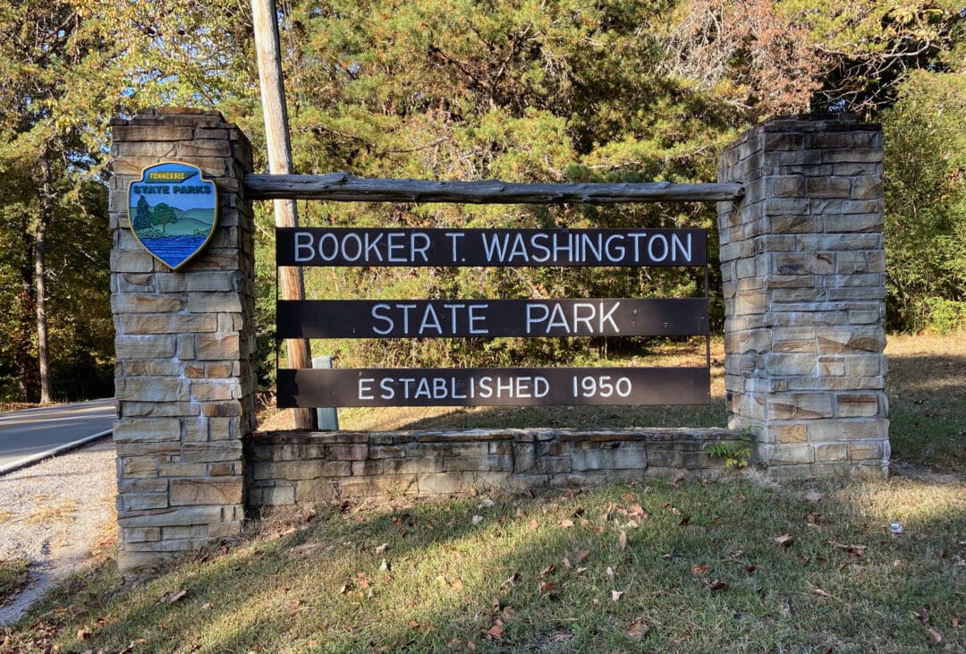 The entrance sign for Booker T. Washington State Park is made of stone and wood