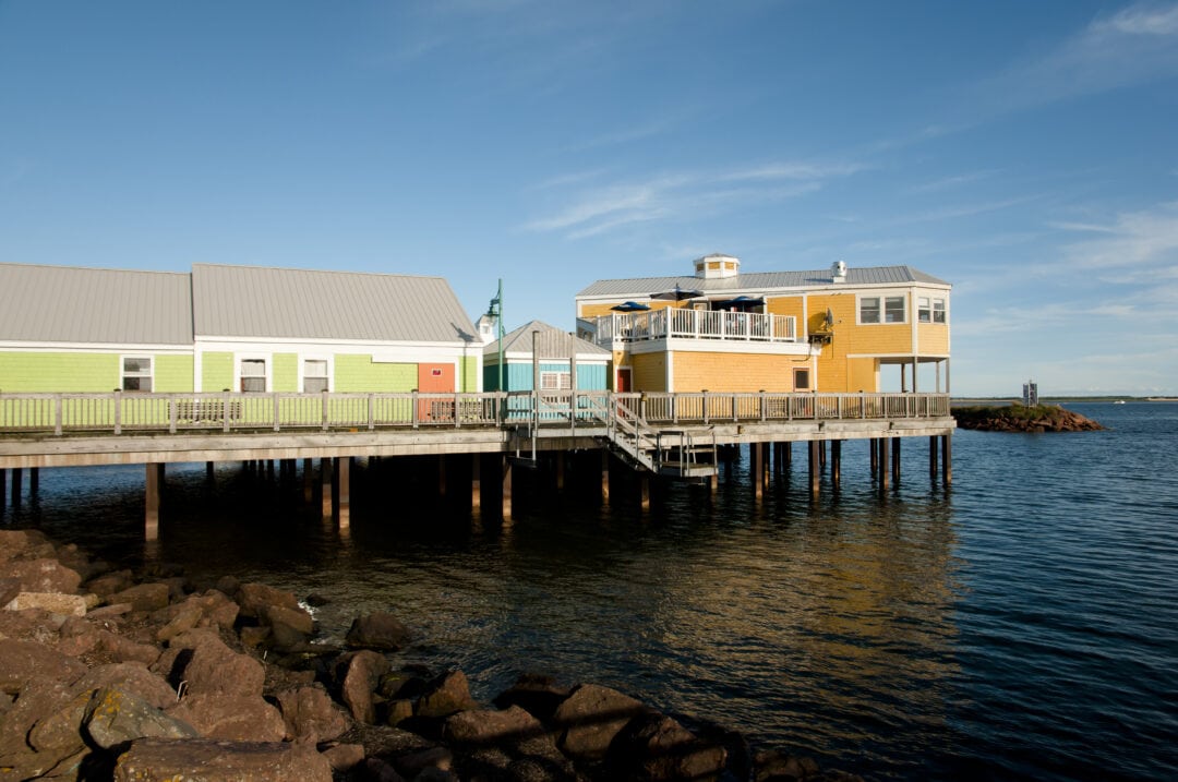 Small buildings on top of a pier over water